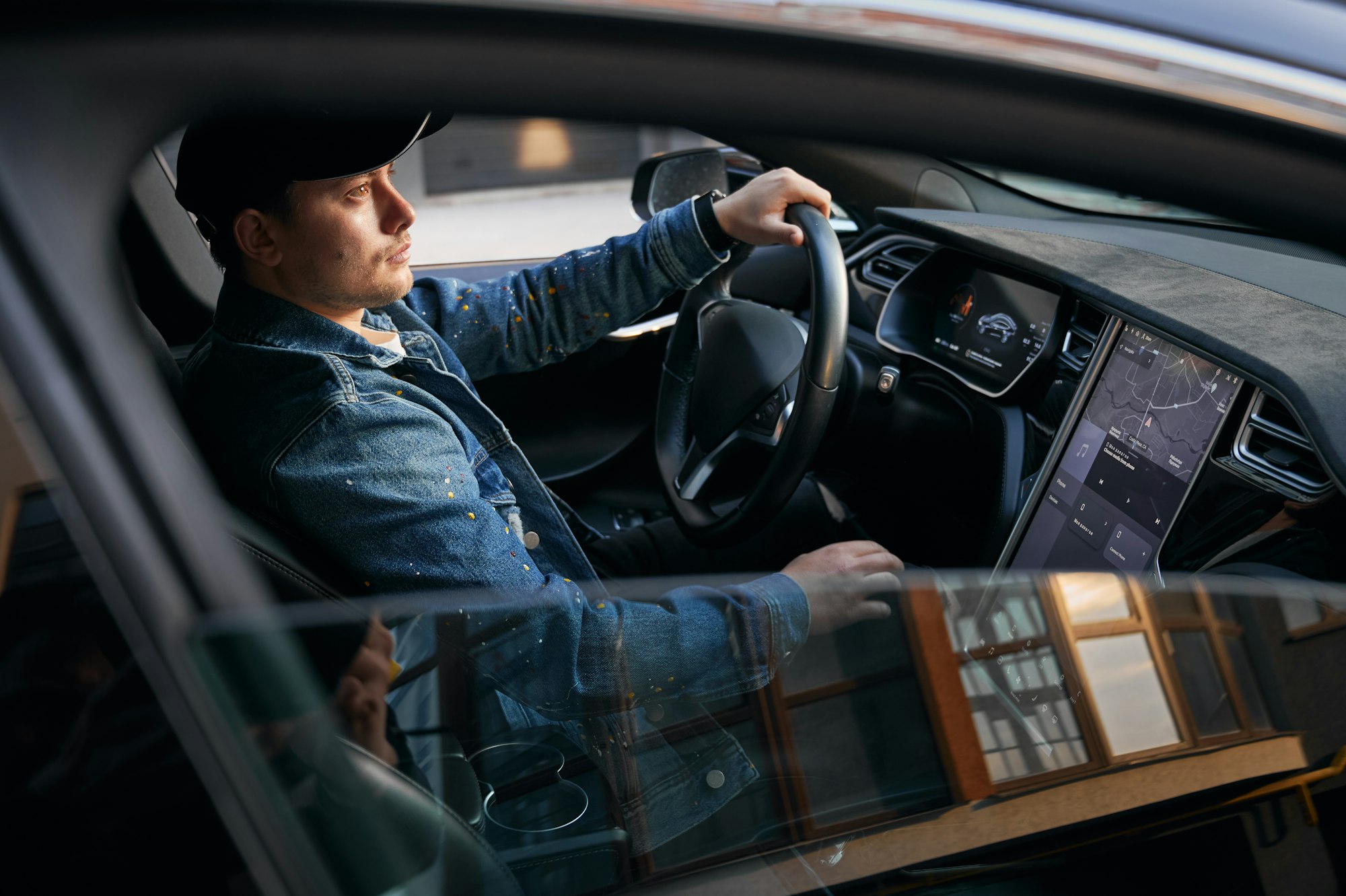 Guy driving car using touch screen on control panel.